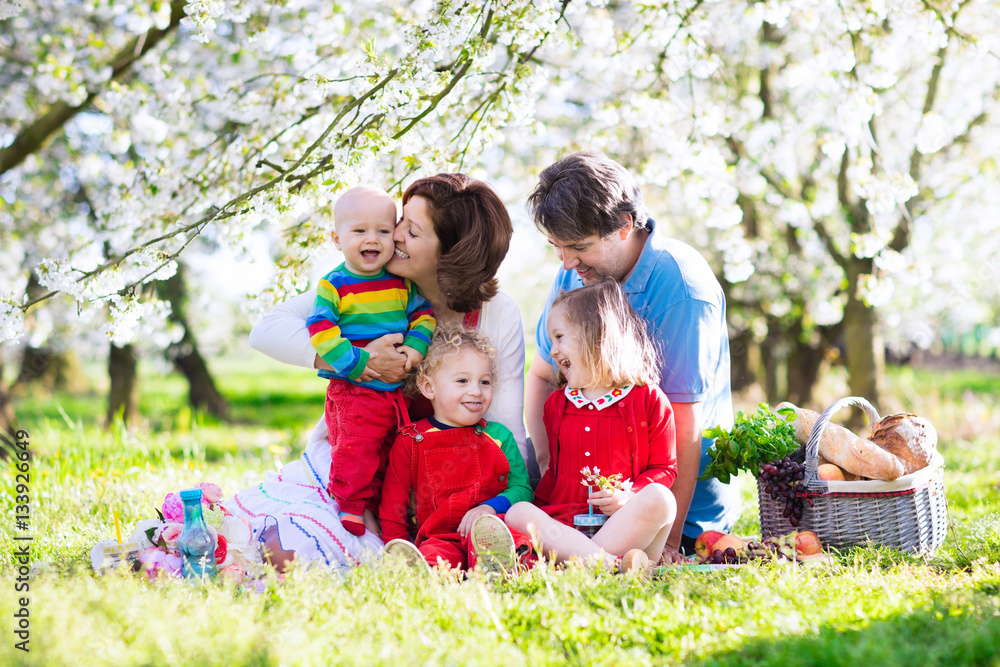 Fototapeta premium Family with kids on picnic in spring garden