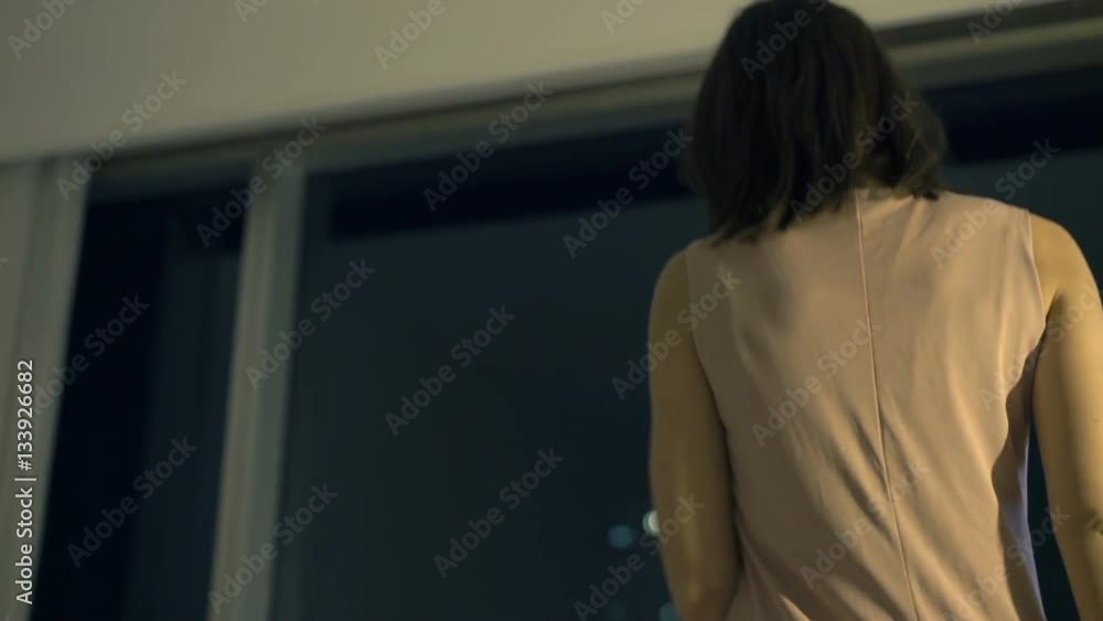 Elegant woman taking off jacket and shoes, sitting on armchair by window at night
Elegant woman taking off jacket and shoes, sitting on armchair by window at night