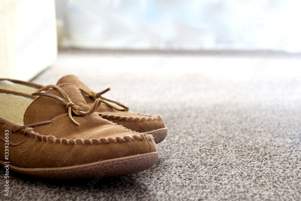 Perforatie Moskee Blootstellen Generic mens suede moccasin slippers on carpet next to sofa in a Stock  Photo | Adobe Stock