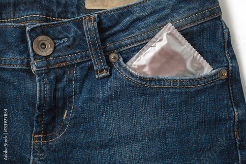 Condoms in package in jeans. Safe sex concept. Healthcare medicine, contraception and birth control. Close Up oral contraceptive pills. Protection against unwanted pregnancy. Protection against AIDS