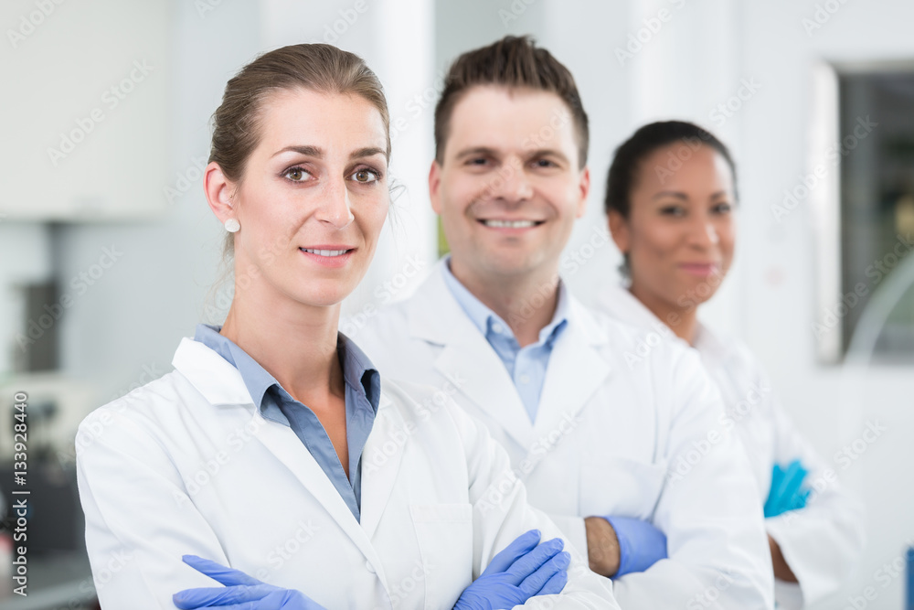 Group of scientists with gloves and gowns in laboratory Group of scientists with gloves and gowns in laboratory