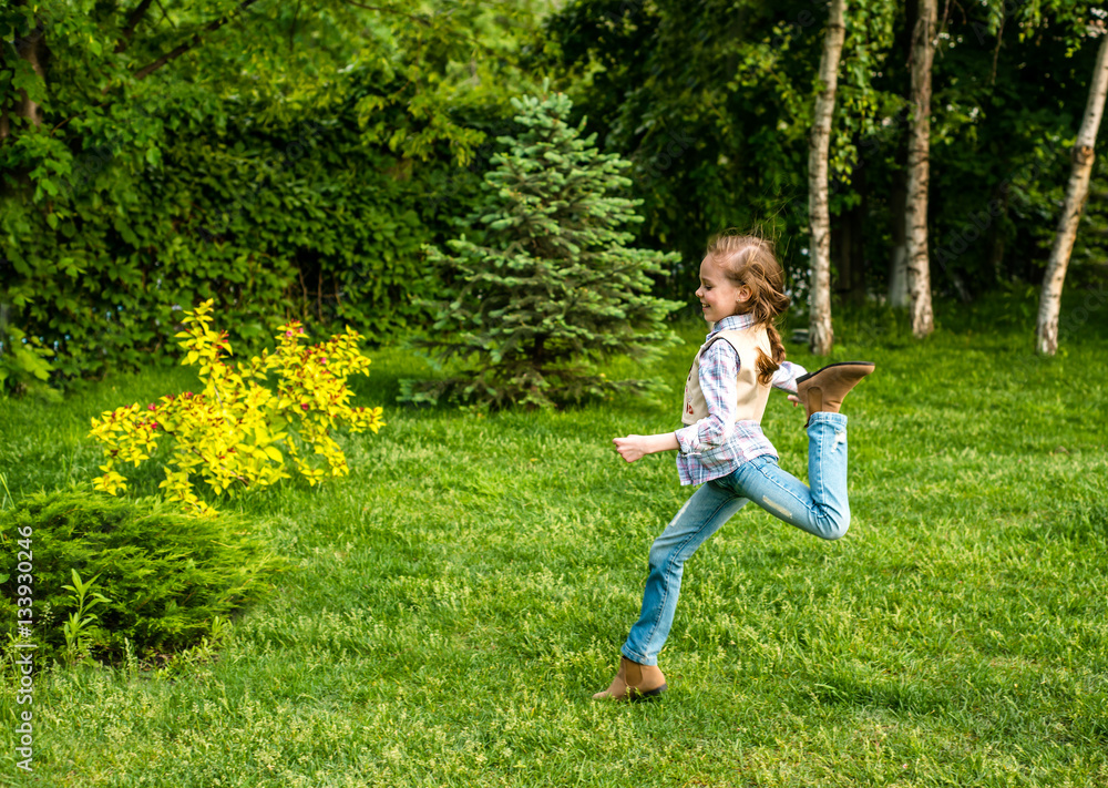 Happy little kid girl jumping on the summer meadow. Happy little kid girl jumping on the summer meadow.