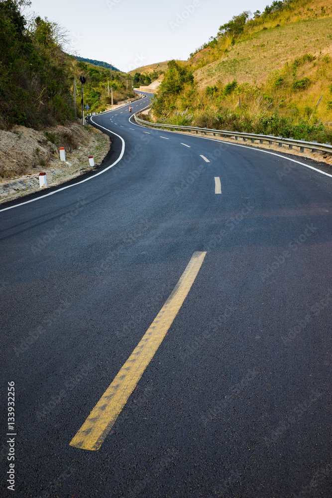 Obraz premium Infinity curved road with yellow line. Concept of adventure, travel, success...