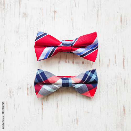 Men's accessories with plaid bow tie on rustic wooden background 