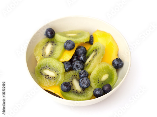 mango, kiwi and blueberries in a bowl on a white background