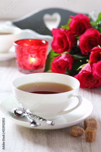 Romantic morning Tea for two with candles and bouquet of roses