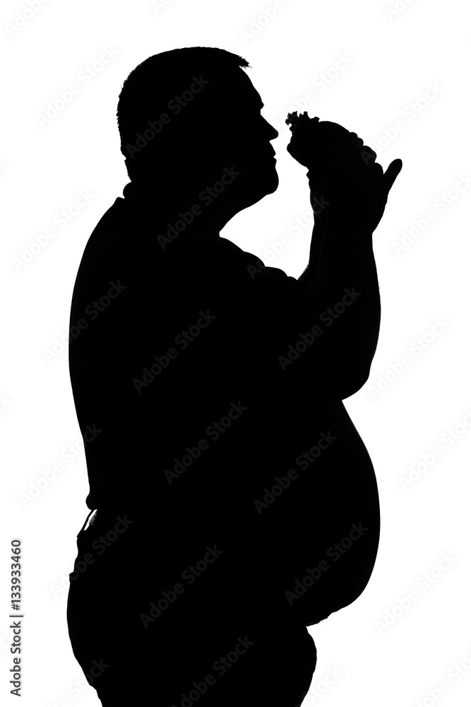 silhouette of men with obesity who eats a hamburger