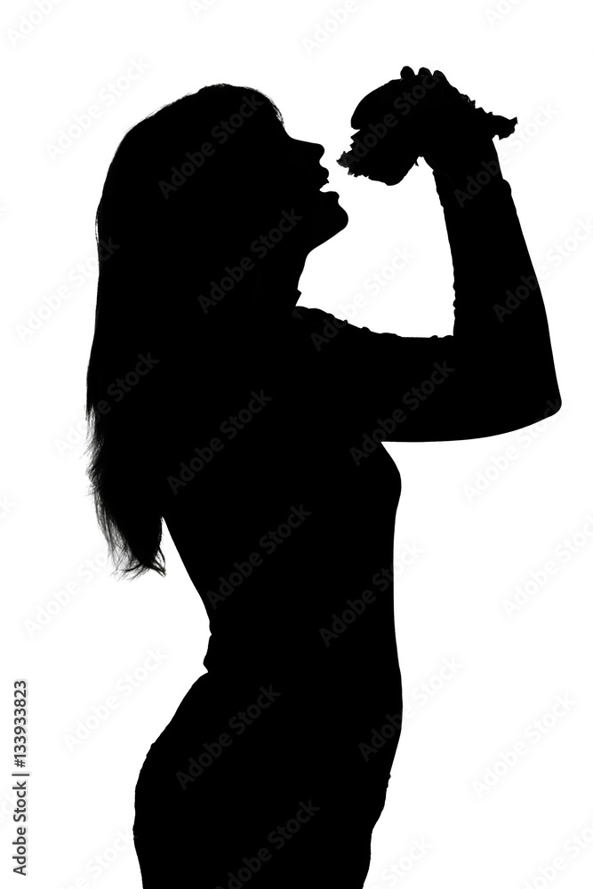 silhouette of a teenager eating a hamburger