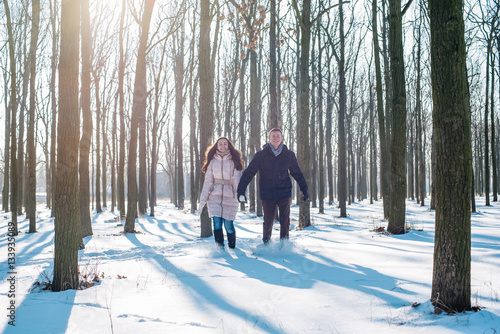 young loving couple having fun in snowy park 