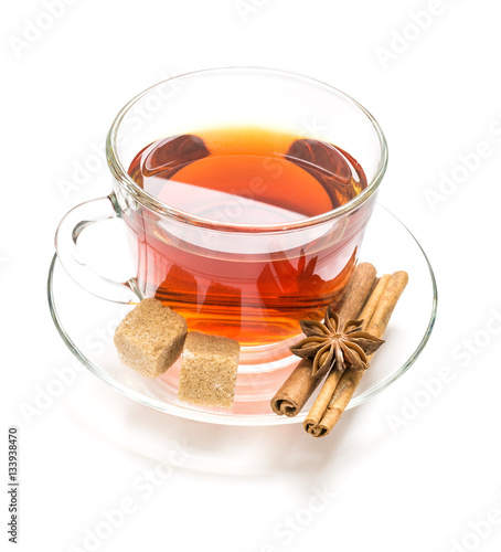 Obraz na płótnie Transparent cup tea, sugar, anise and cinnamon steaks on white w salonie