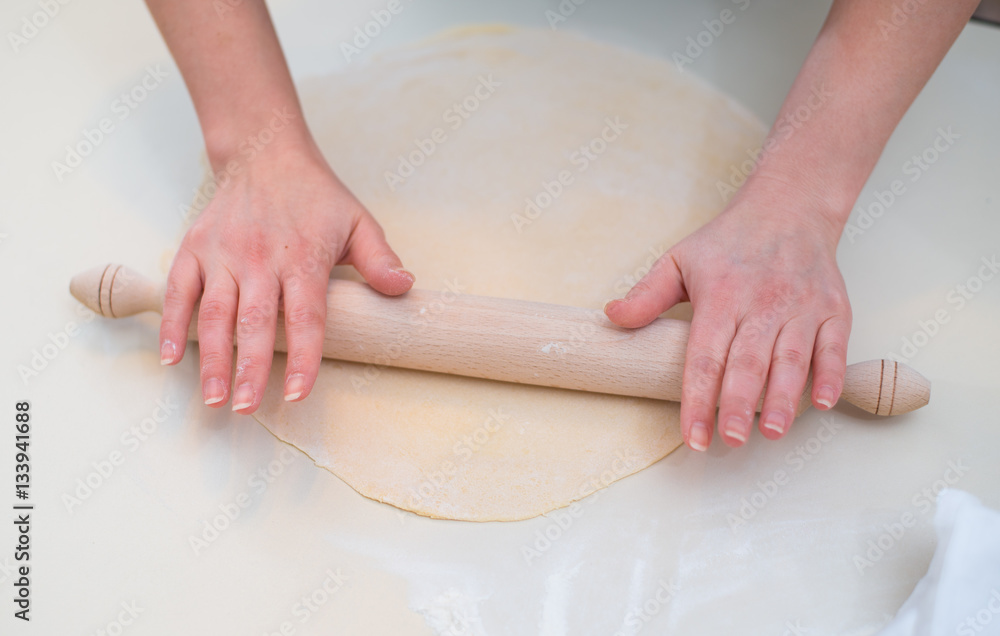 Mother and Daughter Hands Kneading Dough on the table.