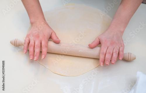 Mother and Daughter Hands Kneading Dough on the table. © pelinoleg