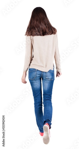 back view of walking  woman in jeans . photo