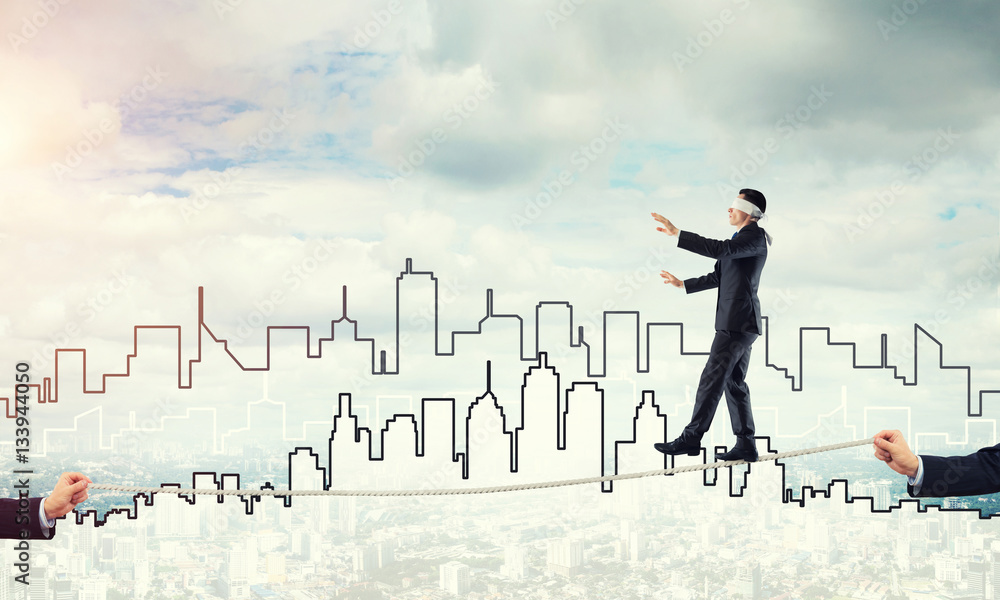 Business concept of risk support and assistance with man balancing on rope Business concept of risk support and assistance with man balancing on rope