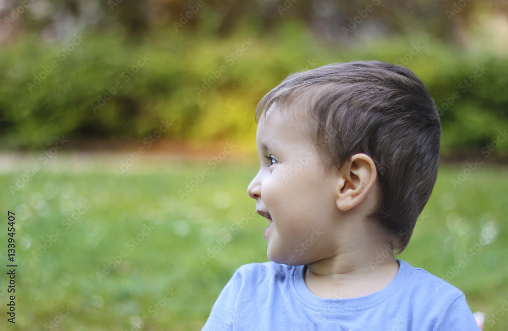 happy little kid looking to the left in the park happy little kid looking to the left in the park