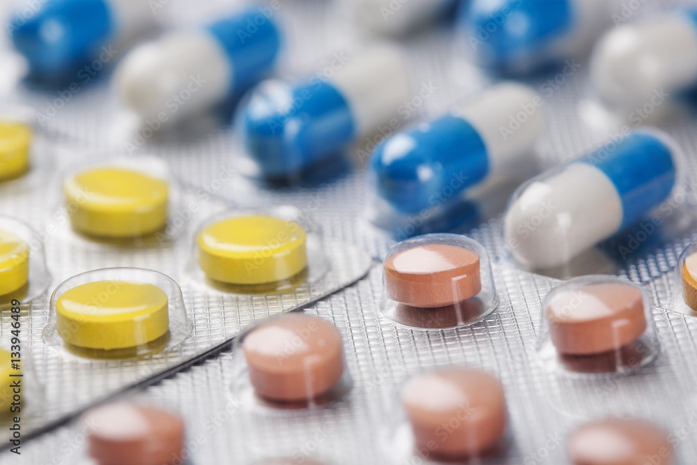 medical pills in different colors in plastic containers medical pills in different colors in plastic containers