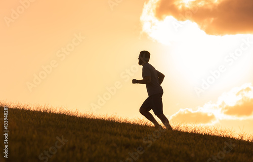 Male runner running up a hill. 