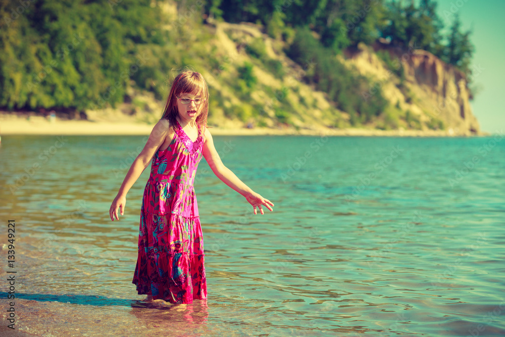 Toddler girl wearing dress playing in water Toddler girl wearing dress playing in water