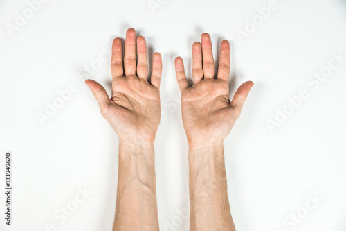 Top view of hands of man on white table. Palms of a male person shot from top view with natural shadows