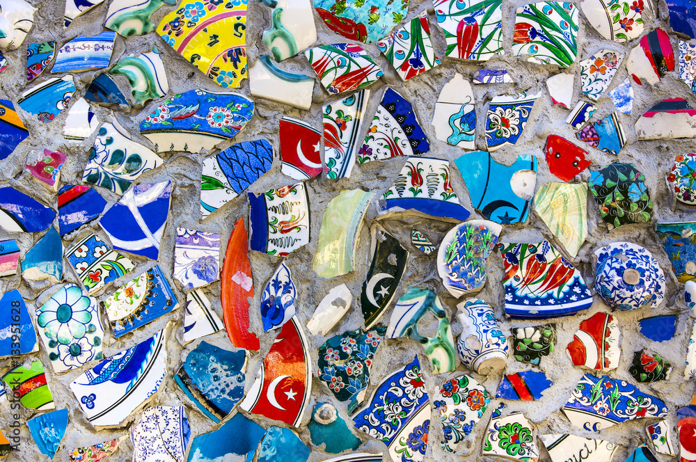 Fototapeta premium Wall with broken ceramic plates colored fragments