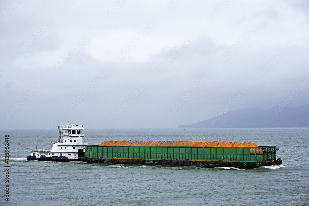 pusher tug and barge going up the Columbia river in Astoria Oregon