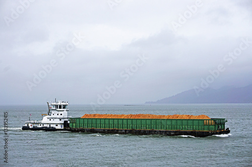 Valokuva pusher tug and barge going up the Columbia river in Astoria Oregon