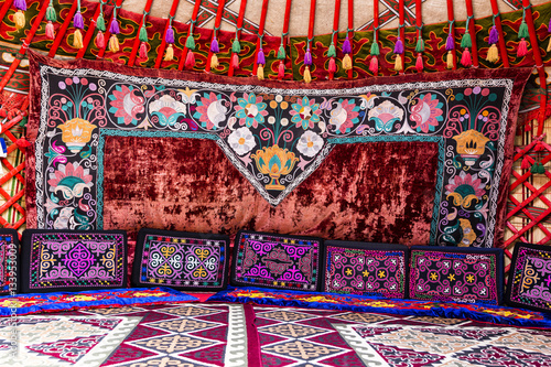Traditional carpet, rug and pillow treatment details in the interior of a nomadic yurt
