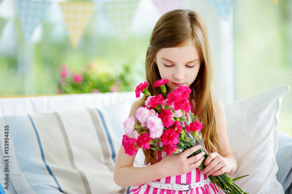 Adorable smiling little girl holding flowers for her mom Adorable smiling little girl holding flowers for her mom