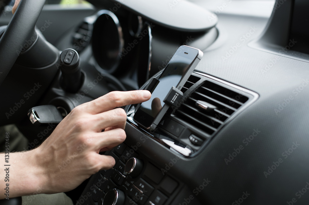 Male hand using GPS on smart phone in car