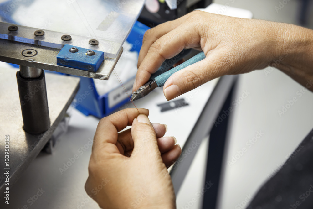 Cropped image of technician turning wire with tweezers in industry Cropped image of technician turning wire with tweezers in industry