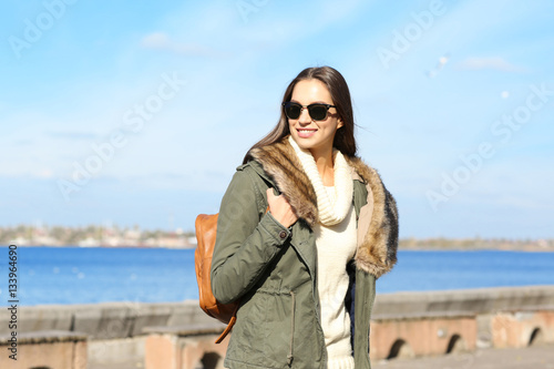 Beautiful young woman at seashore on sunny autumn day © Africa Studio