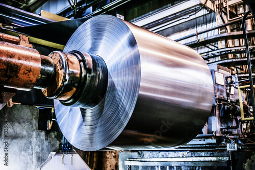 Metal sheet being processed in machinery at industry