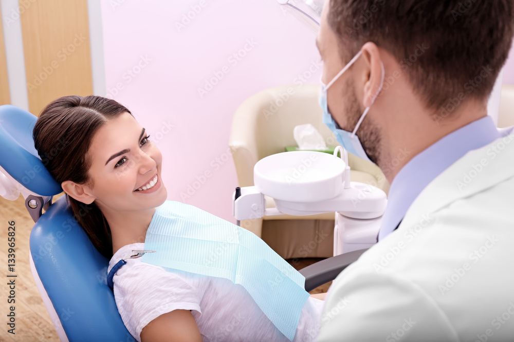 Fototapeta premium Young woman visiting dentist in clinic