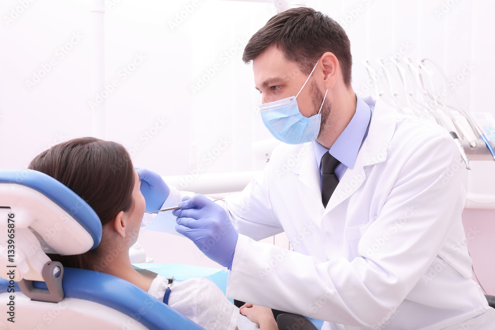 Fototapeta premium Dentist examining patient's teeth in clinic