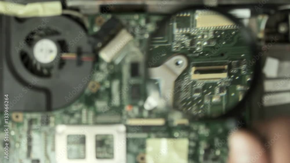 Engineer inspects laptop motherboard under the magnifying glass Stock ...