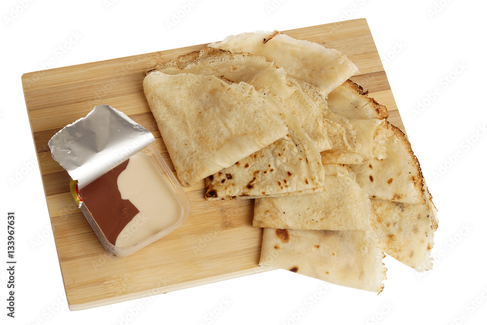 Freshly baked rolled blinis or crepes on wooden board