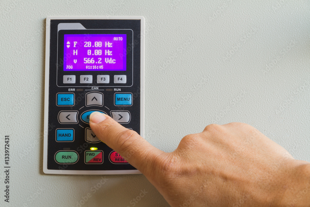Forefinger touch on enter switch on control panel for machine controller. Forefinger touch on enter switch on control panel for machine controller.