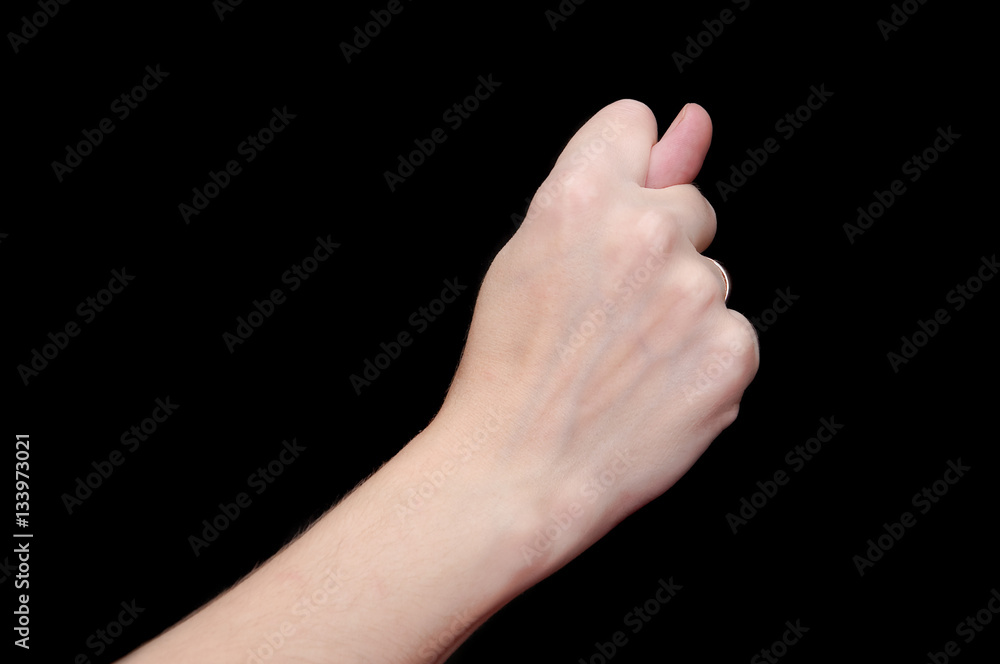 The fig sign or the combination of three fingers is an obscene gesture commonly used to deny a request. Hand isolated on black background The fig sign or the combination of three fingers is an obscene gesture commonly used to deny a request. Hand isolated on black background