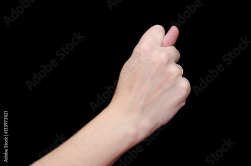 The fig sign or the combination of three fingers is an obscene gesture commonly used to deny a request. Hand isolated on black background