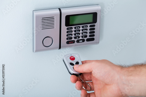 Person Hand Using Remote To Operate Security System