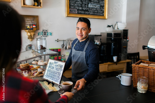 Customer receiving their coffee from the barista