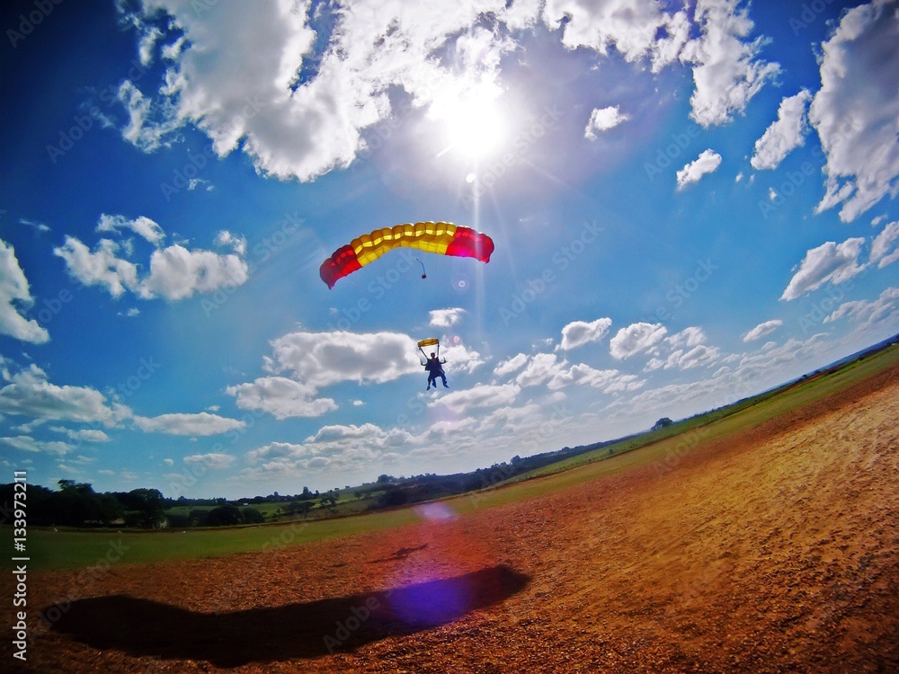 Parachute tandem landing with lens flare - obrazy, fototapety, plakaty 