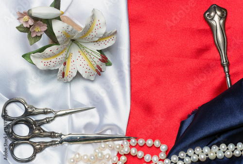 Canvastavla Antique sewing tools, porcelain lily and a pearl necklace on a s