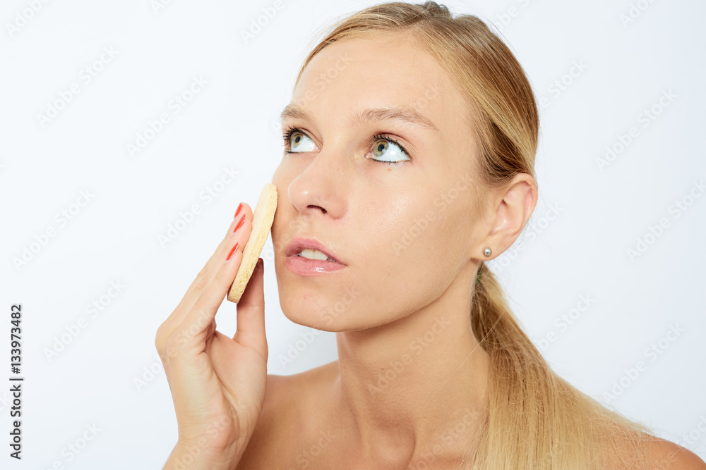 Woman cleaning her face. Beautiful young woman with clear-up pat