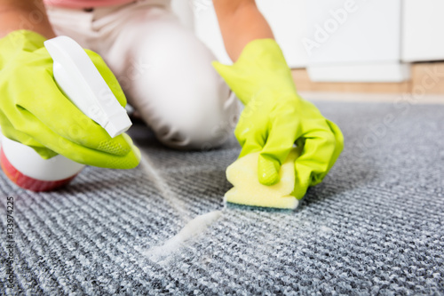 Woman Spraying Detergent On The Carpet