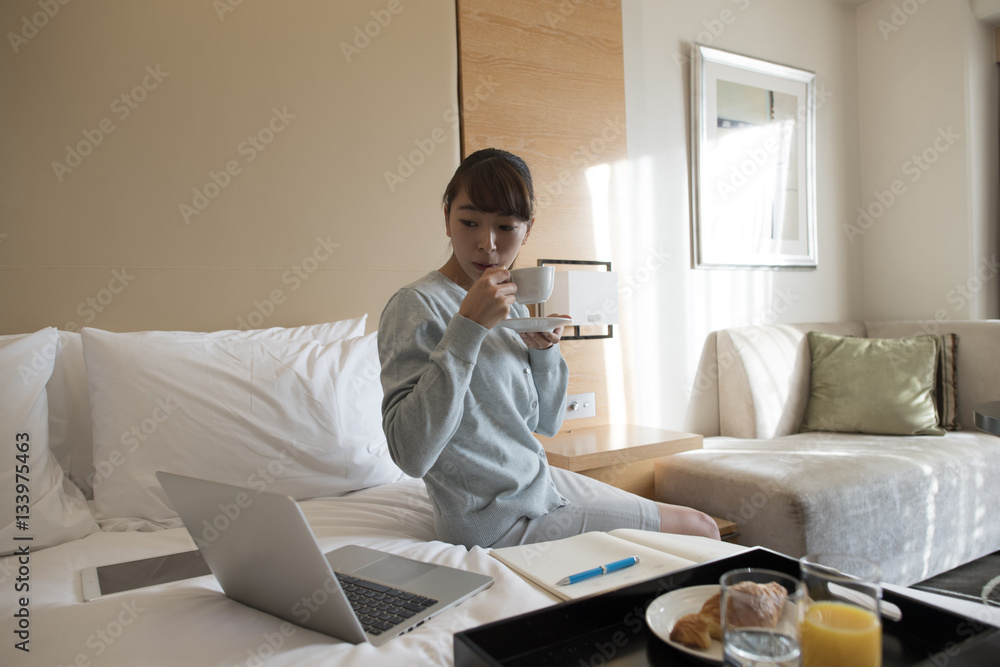Obraz premium The lady is checking out the PC while eating breakfast