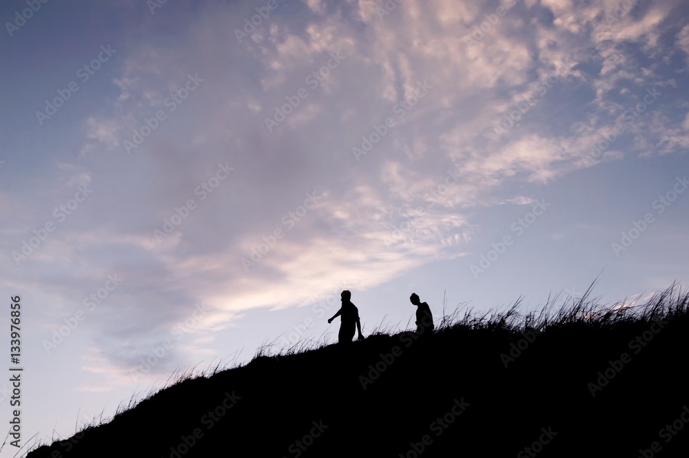 Silhouette of people walking on the hill at mountain