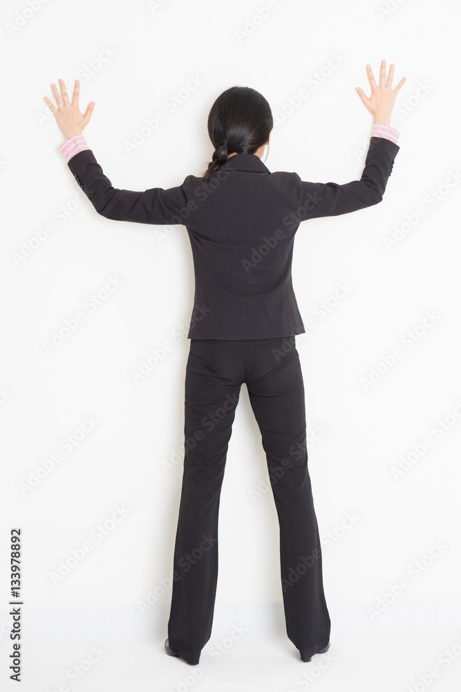Asian businesswoman banging on wall Asian businesswoman banging on wall