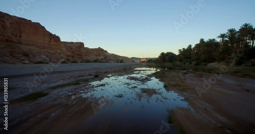 Aerial, Flying Over Palm Oasis Along Mountains At Tissint, Morocco- Graded and stabilized version. Watch also for the native material, straight out of the camera photo