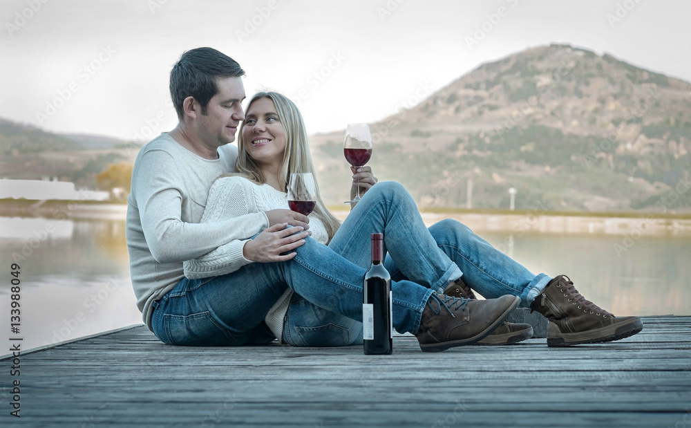 Romantic Couple sitting on the pier with red wine. Romantic Couple sitting on the pier with red wine.